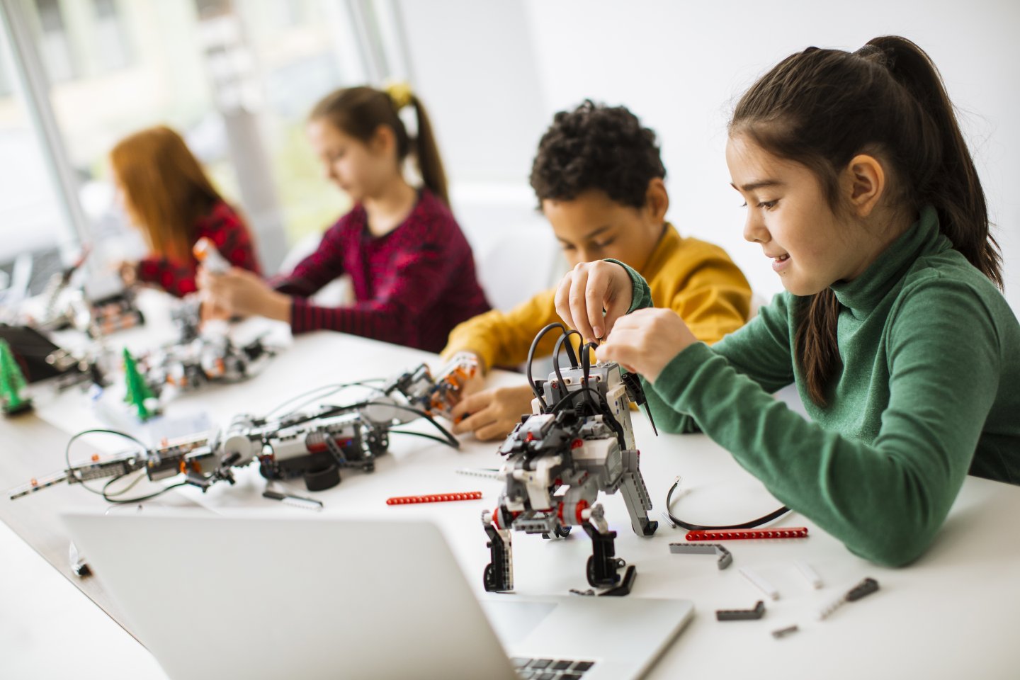 Immagine di copertina dell'articolo sulla robotica educativa con ragazzi e ragazze che costruiscono un robot