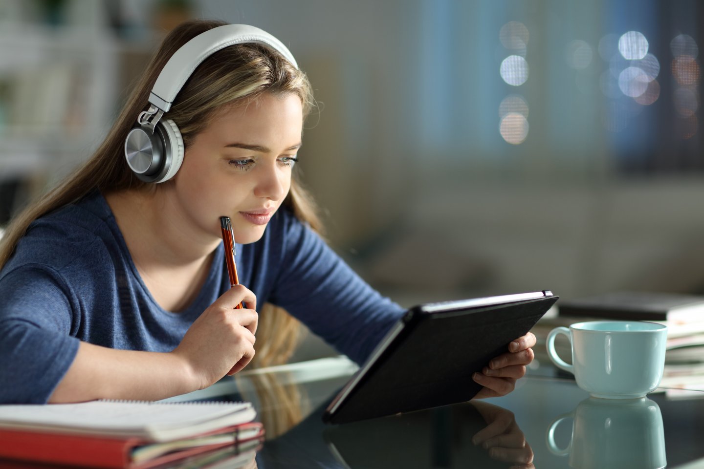 Studente che utilizza un libro elettronico a scuola con tablet e cuffie durante una lezione di e-learning e didattica digitale