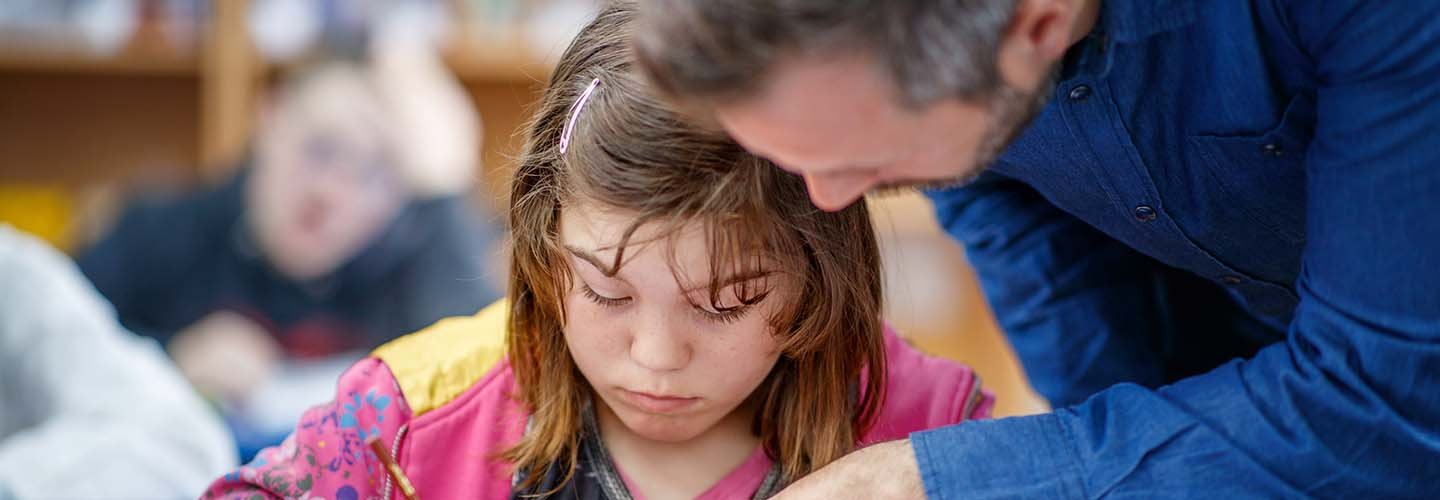 Studentessa con difficoltà di apprendimento (DSA) assistita da insegnante durante le attività scolastiche
