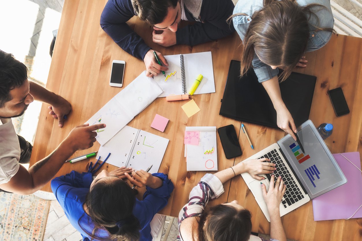 Studentesse e studenti collaborano a un’attività didattica utilizzando quaderni e strumenti digitali