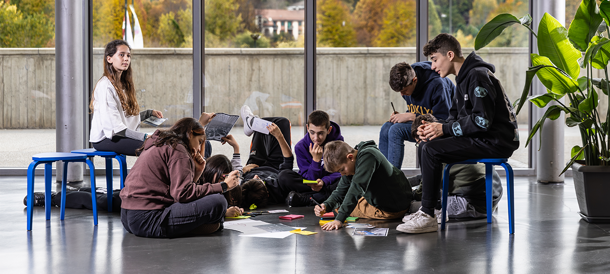 Grafica di copertina del progetto Scuola di Futuro, con dei ragazzi che progettano un futuro smart